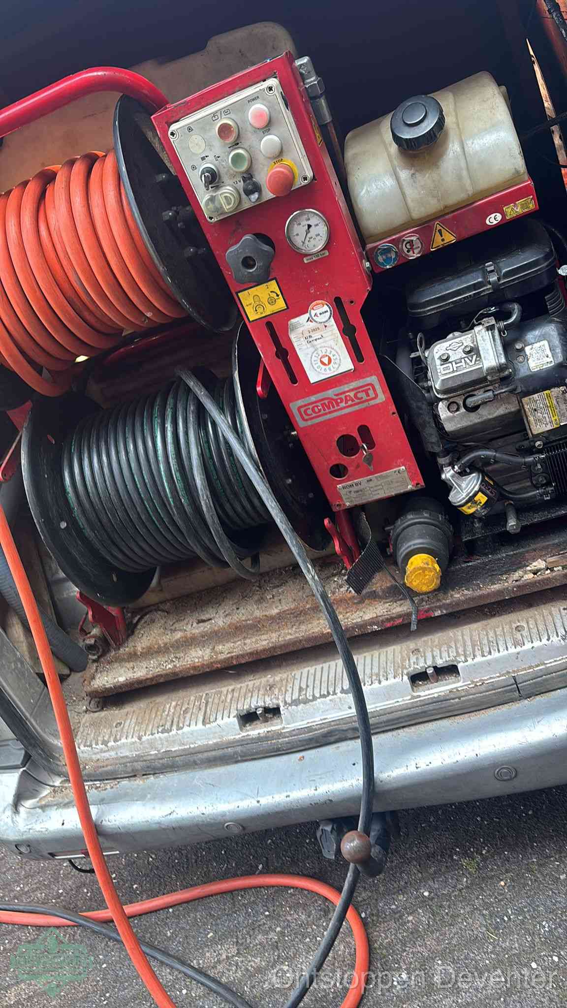 Een rood hogedruk-rioolreinigingstoestel in de laadbak van de bedrijfsbus, apparatuur voor een hardnekkige afvoerverstopping in Deventer