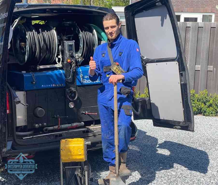 Een monteur bij de werkbus met grote hogedruk-slanghaspels, apparatuur voor hardnekkige afvoerverstoppingen in Deventer