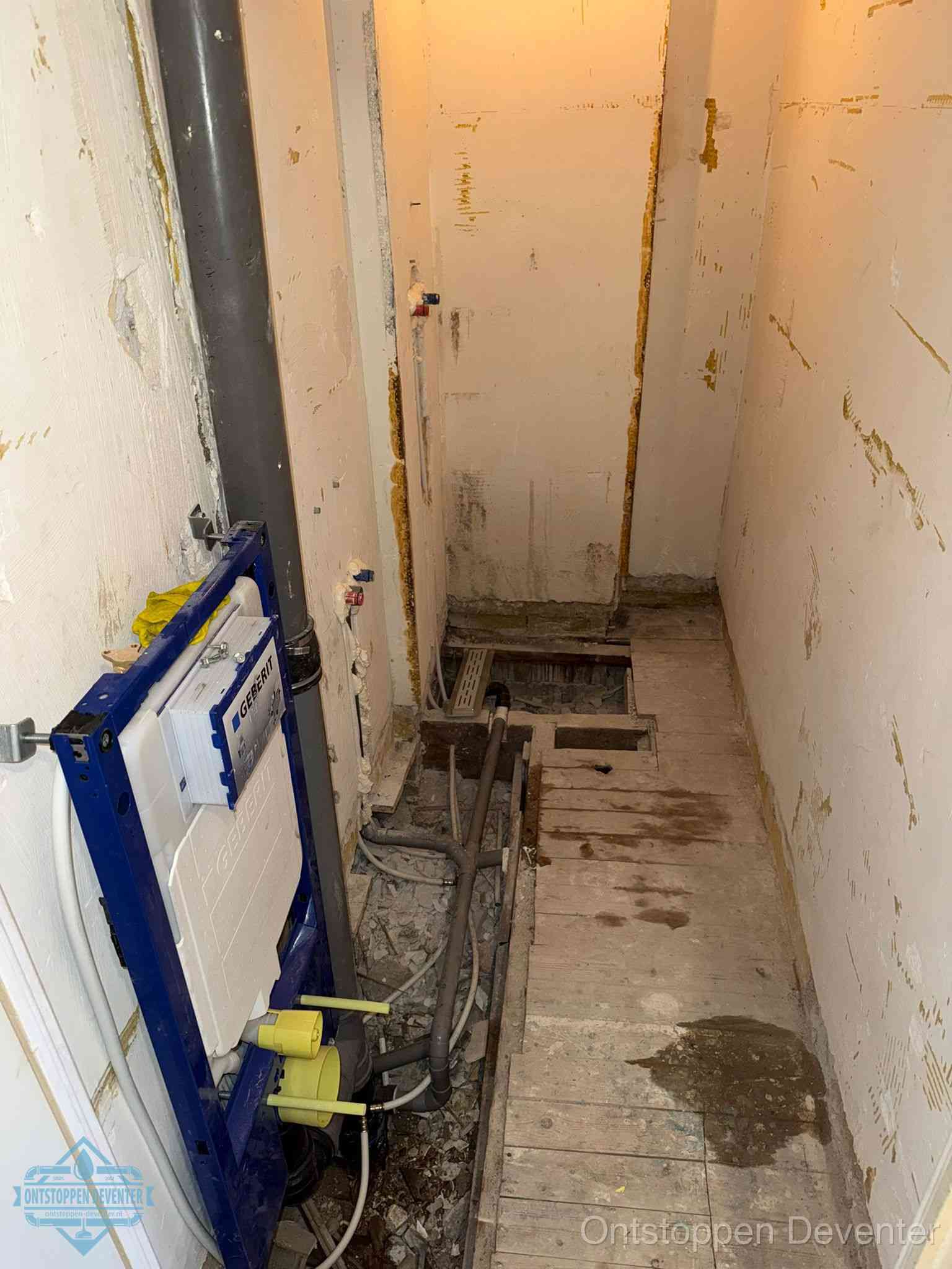 Een opgebroken toiletruimte tijdens renovatie met een Geberit inbouwreservoir en blootliggende oude afvoerleidingen, typisch voor oudere woningen in Deventer